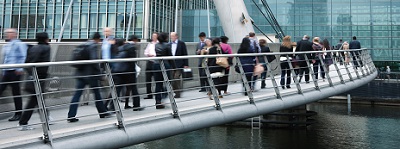Many people walk over a bridge